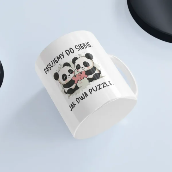 Uroczy kubek z pandą na białym tle przedstawiający pandy trzymające dwa pasujące puzzle